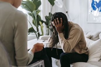 Stressed black man with dreadlocks in psychological office